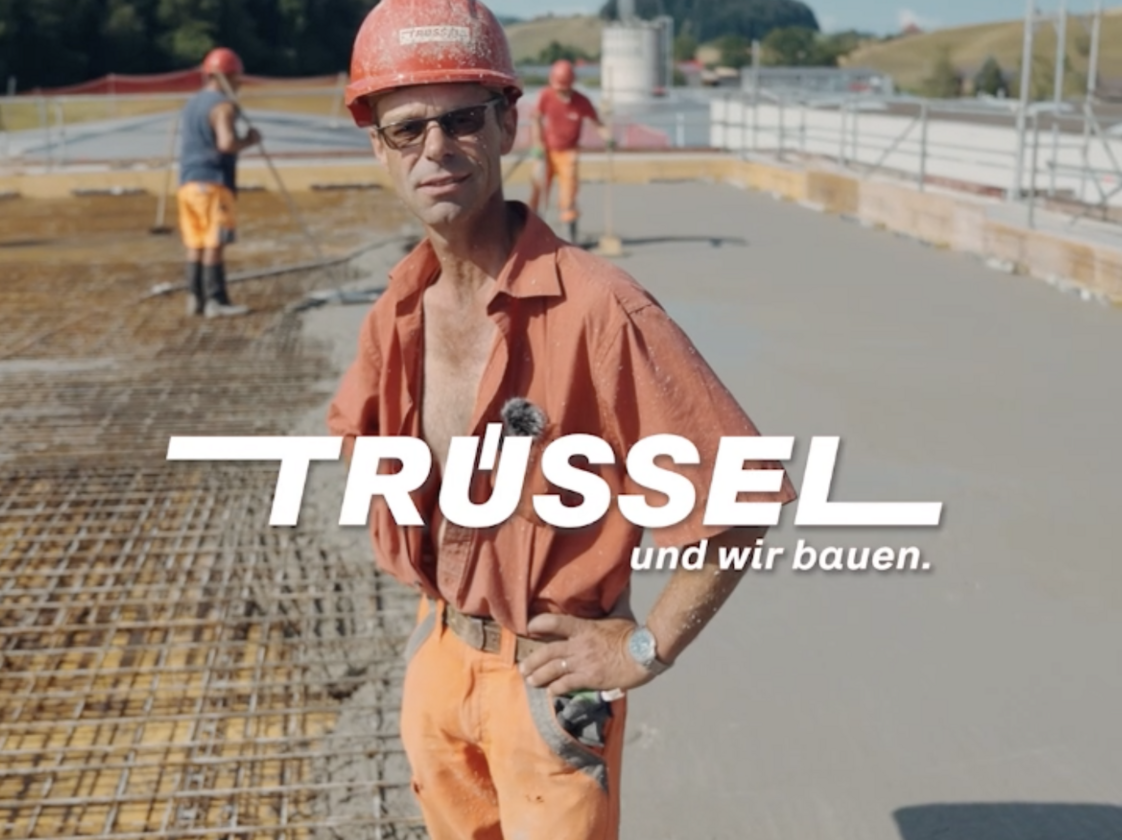 Mitarbeiter von Trüssel auf einer Baustelle mit eingeblendetem Logo Trüssel und wir bauen